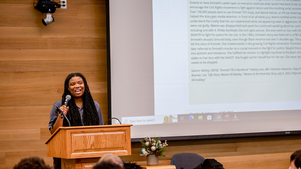 A photo of a college student speaking at a black studies event