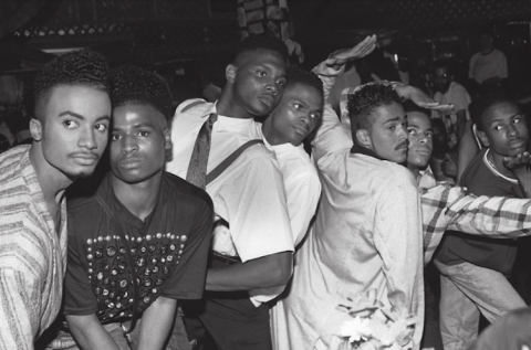Black and white photo depicting a small crowd of Black LGBTQ people at a Ball, circa 1990